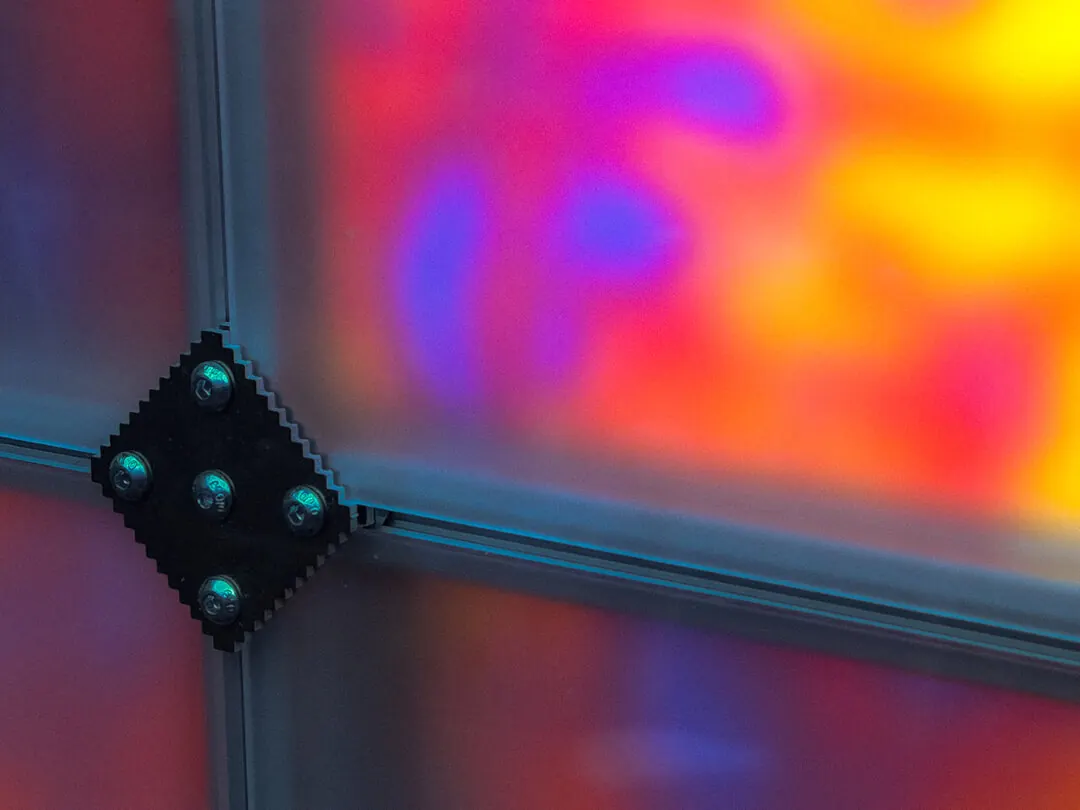 A bolted joint against soft magenta and orange light